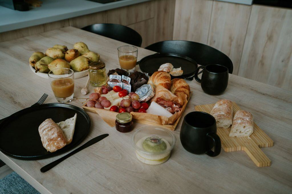 Reggeli asztal tele friss gyümölcsökkel, croissantekkel, kávéval és teával a Lake Forest Kabinben.